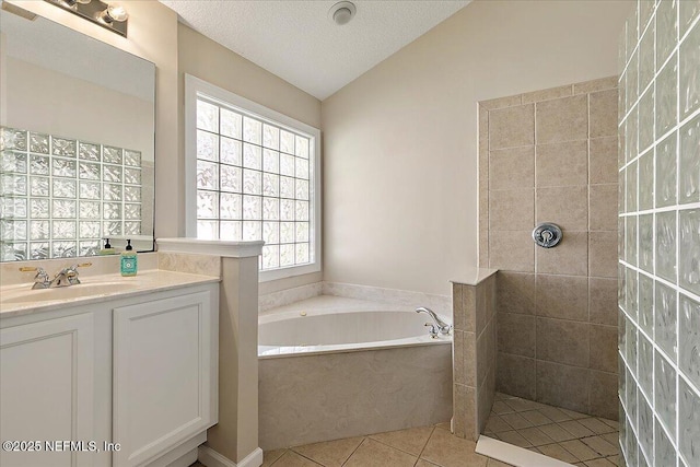 bathroom featuring tile patterned floors, vaulted ceiling, a textured ceiling, vanity, and independent shower and bath