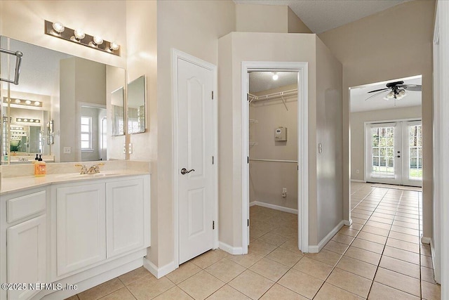 bathroom with tile patterned flooring, vanity, french doors, and ceiling fan