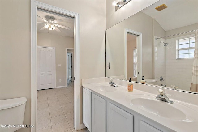 full bathroom with tile patterned floors, toilet, vanity, tiled shower / bath combo, and ceiling fan