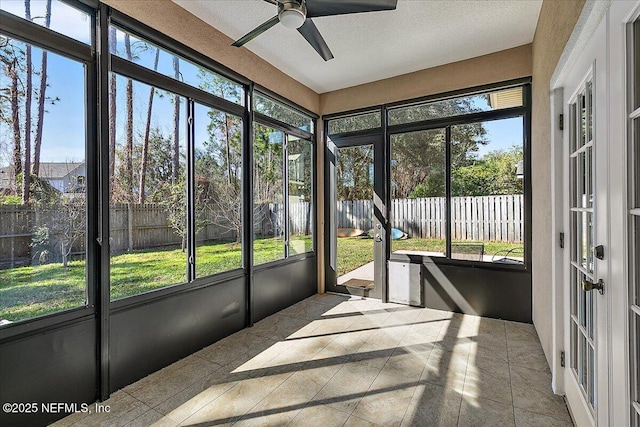 unfurnished sunroom with ceiling fan