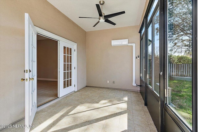 unfurnished sunroom with plenty of natural light, a wall mounted air conditioner, ceiling fan, and french doors