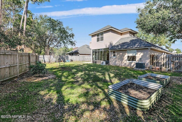 rear view of property featuring a yard and central AC unit