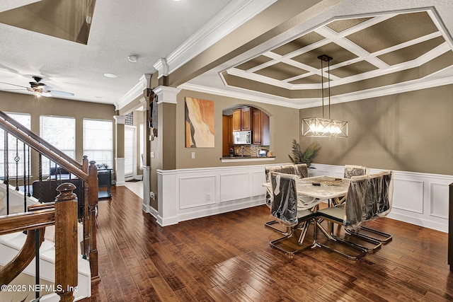 dining room with dark hardwood / wood-style flooring, coffered ceiling, ceiling fan, crown molding, and a textured ceiling