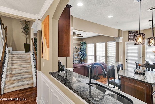 kitchen with pendant lighting, sink, ceiling fan, dark hardwood / wood-style flooring, and ornate columns