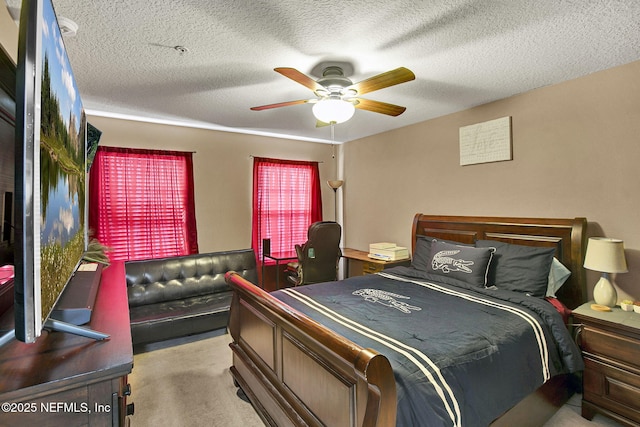 bedroom featuring ceiling fan, light colored carpet, and a textured ceiling