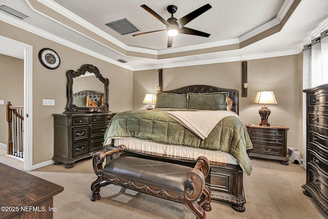 carpeted bedroom with ornamental molding, ceiling fan, and a tray ceiling