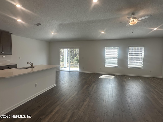 interior space featuring a sink, visible vents, baseboards, and dark wood-style flooring