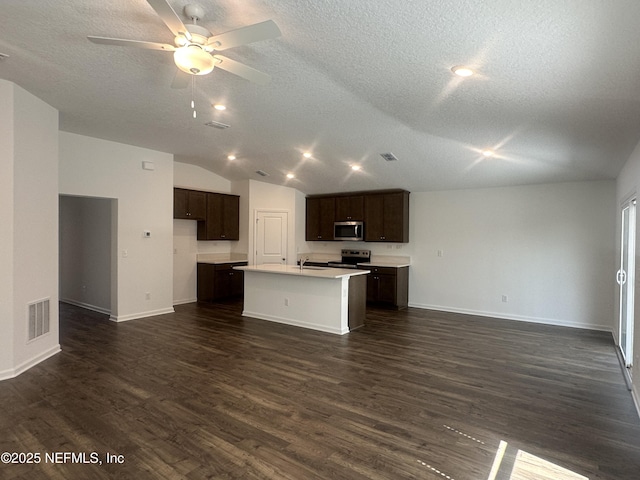 kitchen with visible vents, open floor plan, dark wood finished floors, dark brown cabinetry, and appliances with stainless steel finishes