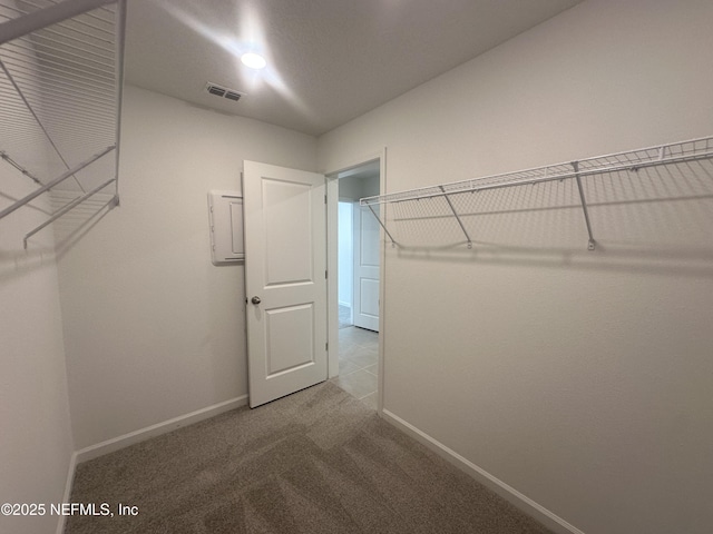 spacious closet with visible vents and carpet floors