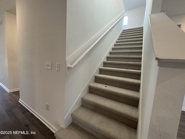 stairway featuring wood finished floors and baseboards