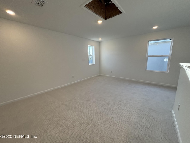 spare room with baseboards, recessed lighting, visible vents, and light colored carpet