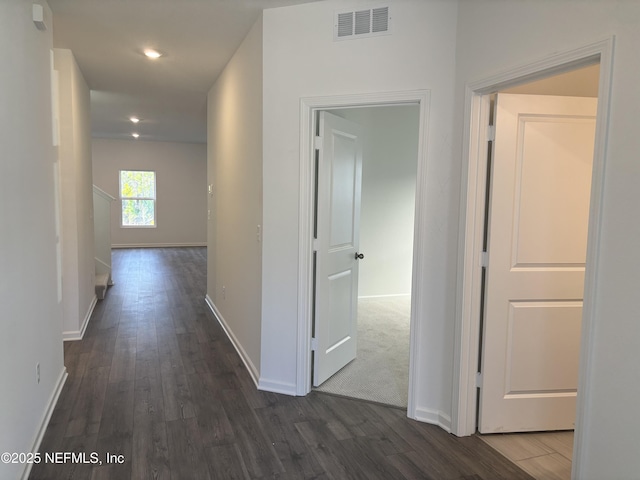 corridor with baseboards, visible vents, dark wood-type flooring, and recessed lighting