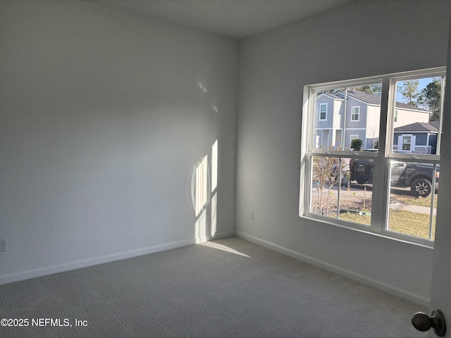 unfurnished room with carpet flooring and baseboards