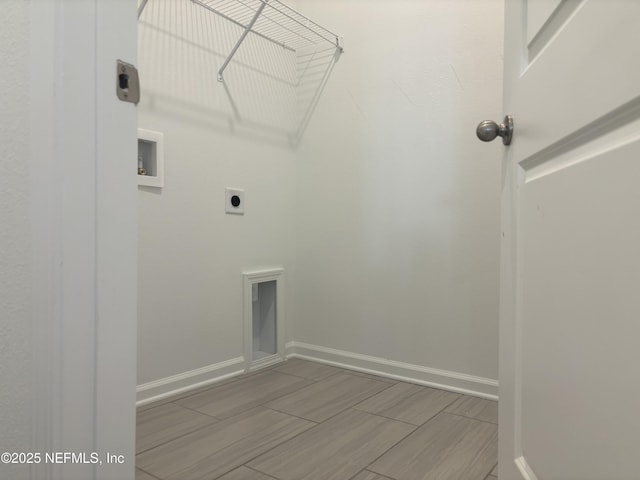 laundry room featuring wood finish floors, hookup for a washing machine, electric dryer hookup, laundry area, and baseboards