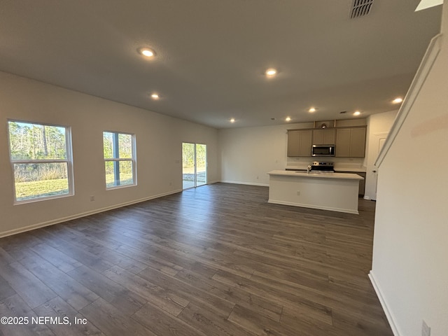 unfurnished living room featuring recessed lighting, dark wood-style flooring, visible vents, and baseboards