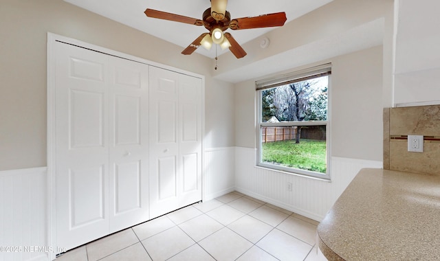 unfurnished bedroom featuring light tile patterned floors, ceiling fan, and a closet