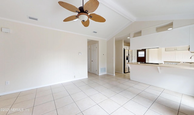 unfurnished living room with sink, crown molding, ceiling fan, lofted ceiling with beams, and light tile patterned flooring