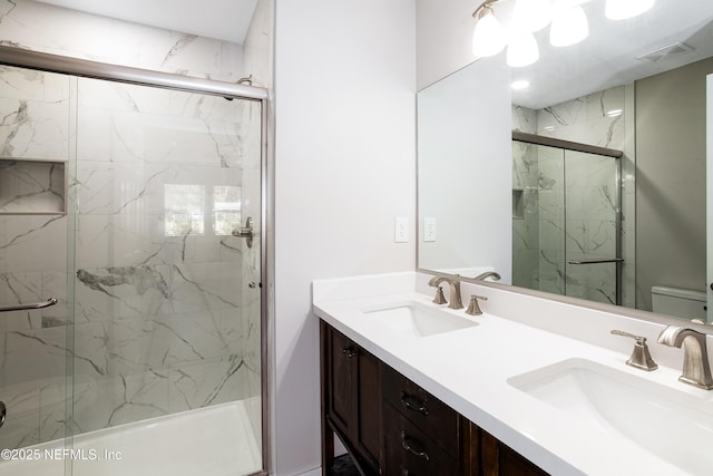 bathroom featuring vanity, toilet, and a shower with shower door