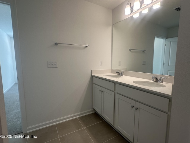 bathroom featuring a sink, visible vents, double vanity, and tile patterned floors