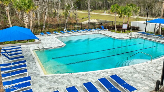 community pool featuring a patio and fence