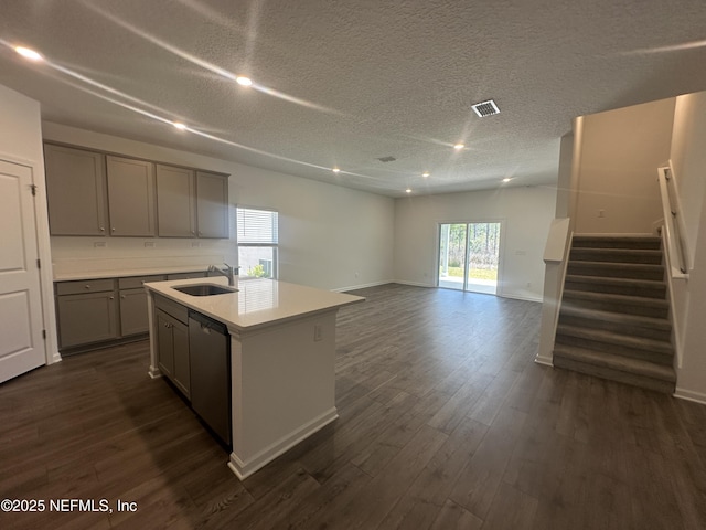 kitchen featuring stainless steel dishwasher, visible vents, dark wood-style flooring, and gray cabinetry