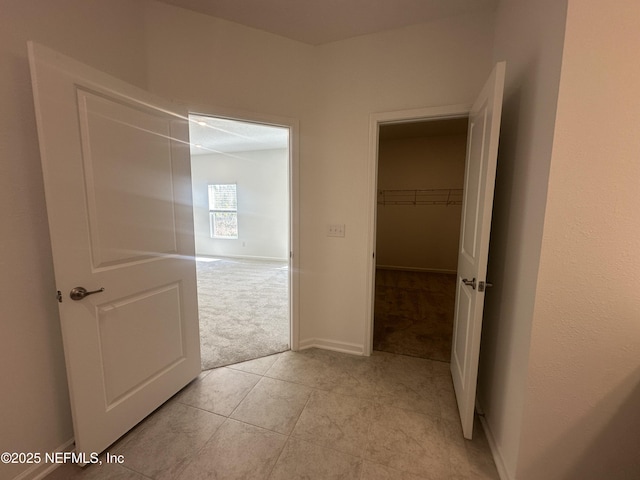 hallway with light carpet and baseboards