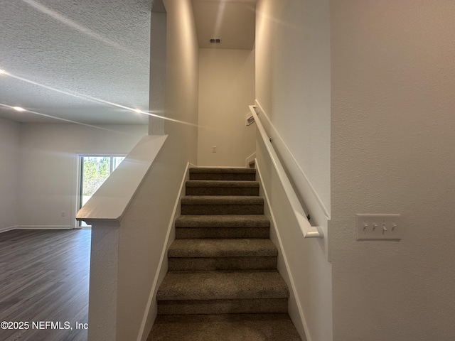 staircase featuring wood finished floors and baseboards