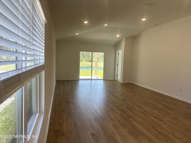 spare room featuring recessed lighting, baseboards, lofted ceiling, and wood finished floors