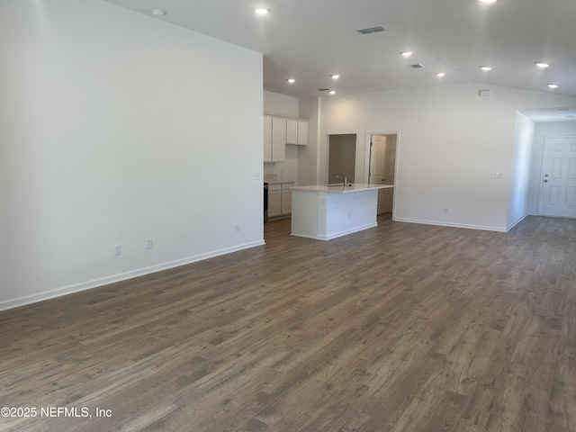 unfurnished living room featuring visible vents, dark wood-type flooring, baseboards, lofted ceiling, and recessed lighting