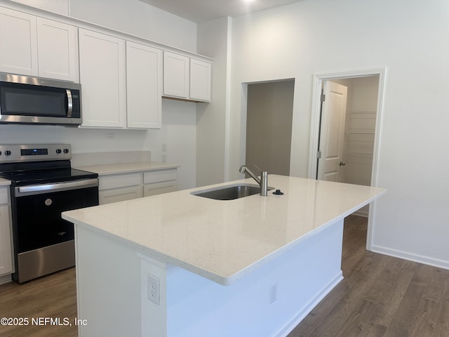 kitchen featuring light stone counters, dark wood-style flooring, a sink, appliances with stainless steel finishes, and white cabinetry