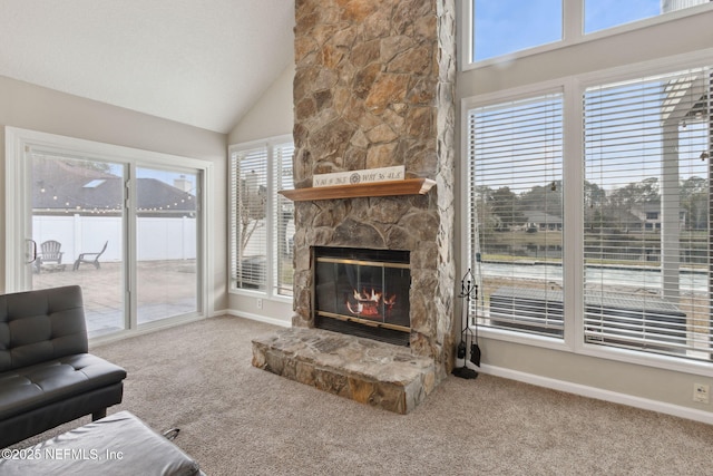 living room featuring a stone fireplace, carpet floors, and high vaulted ceiling