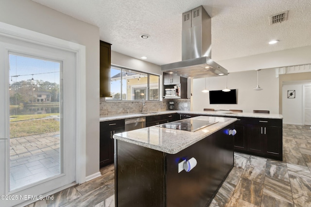 kitchen featuring a kitchen island, decorative light fixtures, island exhaust hood, black electric stovetop, and light stone counters