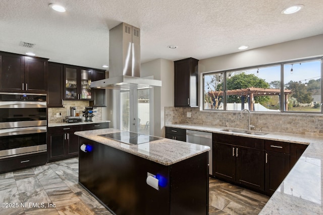 kitchen featuring sink, stainless steel appliances, light stone countertops, and island exhaust hood