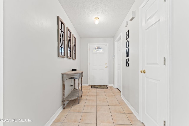 entryway featuring light tile patterned flooring and a textured ceiling