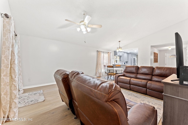 living room with lofted ceiling, ceiling fan, and light hardwood / wood-style flooring