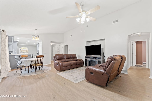 living room featuring ceiling fan, high vaulted ceiling, and light hardwood / wood-style floors