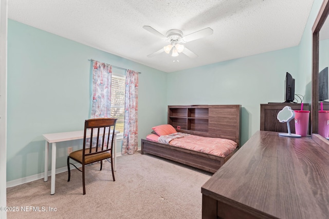 carpeted bedroom featuring ceiling fan and a textured ceiling