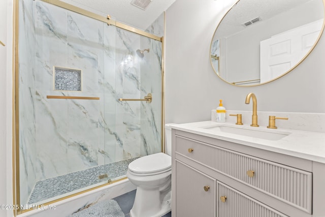 bathroom with an enclosed shower, vanity, a textured ceiling, and toilet