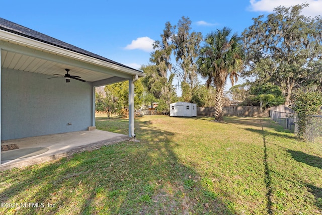 view of yard with ceiling fan, a patio, and a shed