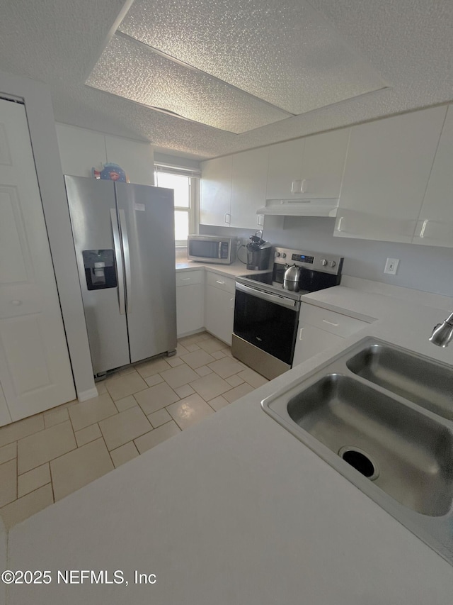4250 A1A S Unit L16, Saint Augustine, FL 32080 - kitchen featuring light countertops, white cabinetry, a sink, appliances with stainless steel finishes, and light tile patterned floors