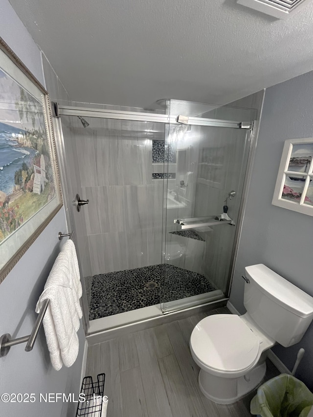 4250 A1A S Unit L16, Saint Augustine, FL 32080 - bathroom with toilet, a textured ceiling, and a shower stall