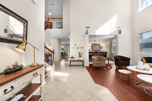 living room with a high ceiling, light hardwood / wood-style flooring, and a notable chandelier