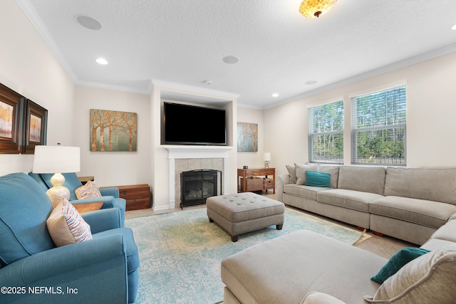 living room with a tiled fireplace, ornamental molding, light tile patterned floors, and a textured ceiling