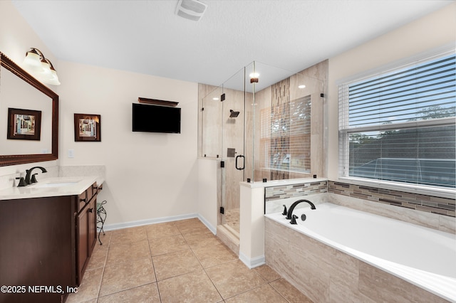 bathroom featuring tile patterned flooring, shower with separate bathtub, vanity, and a textured ceiling