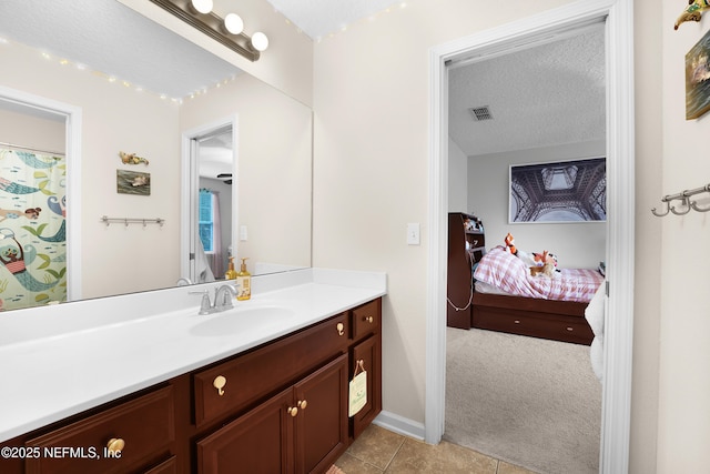 bathroom with tile patterned floors, vanity, and a textured ceiling