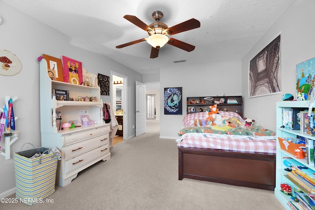 carpeted bedroom with ceiling fan and a textured ceiling