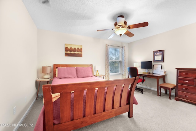 bedroom featuring ceiling fan, light carpet, and a textured ceiling