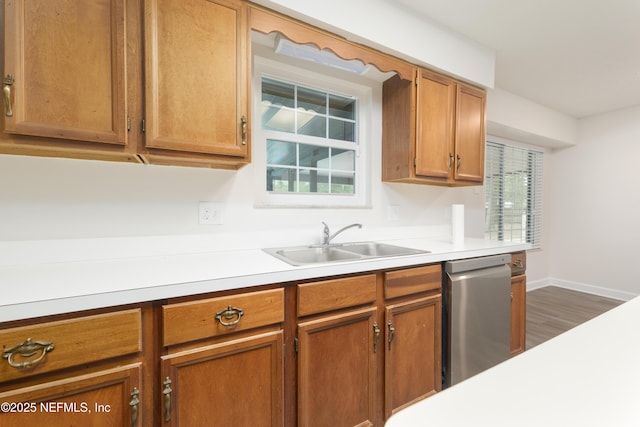 kitchen with stainless steel dishwasher, dark hardwood / wood-style flooring, sink, and a wealth of natural light