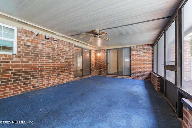 unfurnished sunroom with ceiling fan