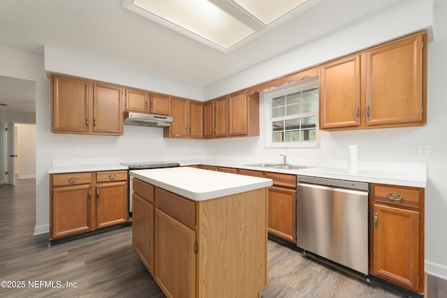 kitchen with sink, a kitchen island, wood-type flooring, and appliances with stainless steel finishes